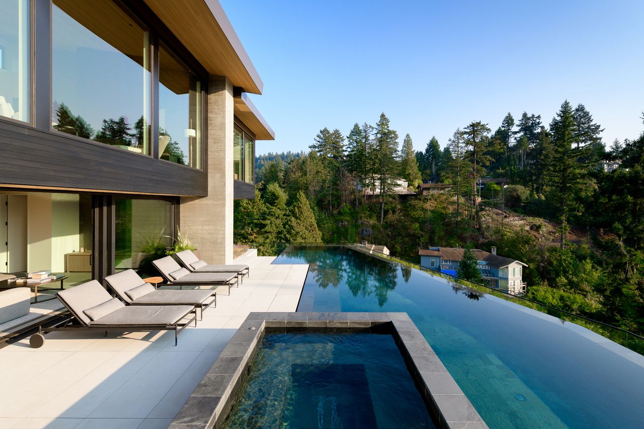 Maple Place house&#039;s exterior paved cascade of terraces with a long lap pool in the middle