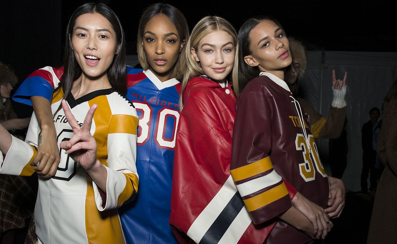 4 girls wearing various leather sports jerseys and jackets 