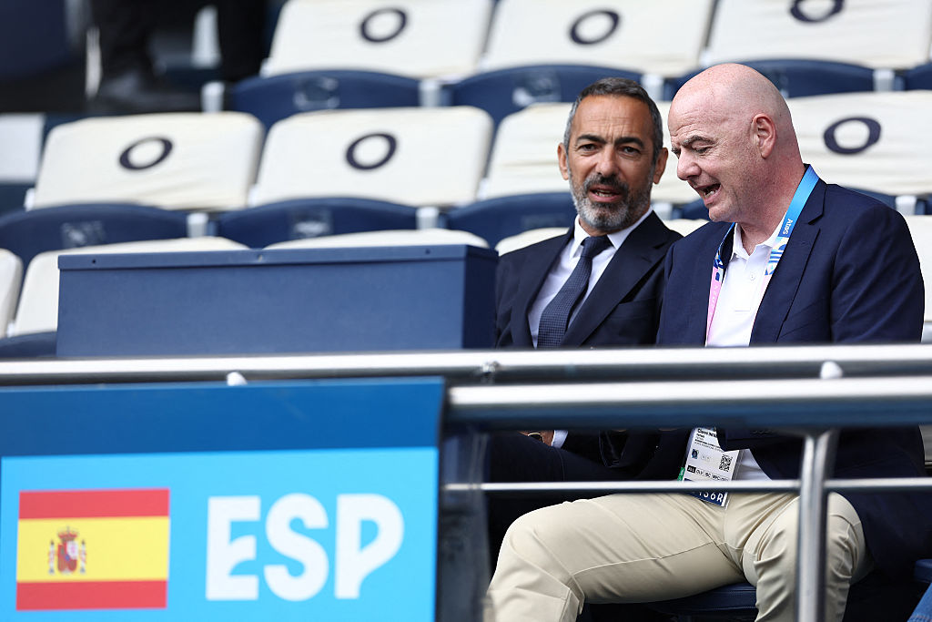 FIFA president Gianni Infantino (R) and French former football international Youri Djorkaeff sit in the tribunes prior to the men's group C football match between Uzbekistan and Spain of the the Paris 2024 Olympic Games at the Parc des Princes in Paris on July 24, 2024. (Photo by FRANCK FIFE / AFP)