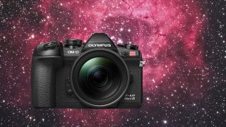 OM System E-M1 Mark III Astro camera superimposed over an image of a vibrant red nebulae