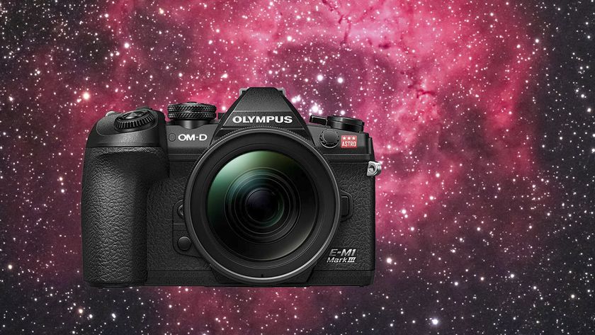 OM System E-M1 Mark III Astro camera superimposed over an image of a vibrant red nebulae