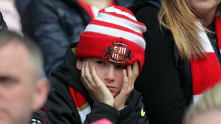 SUNDERLAND, ENGLAND - MAY 13: A young Sunderland fan holds his head in disappointment during the Premier League match between Sunderland and Swansea City at the Stadium of Light on May 13, 2017 in Sunderland, England. (Photo by Athena Pictures/Getty Images)