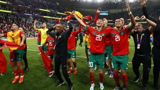 Morocco players and staff celebrate their 1-0 quarter-final win over Portugal