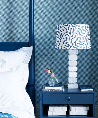 Blue bedroom with patterned wallpaper and lampshade