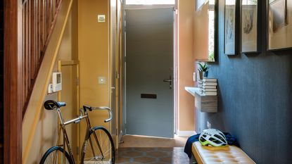 A narrow hallway with one side painted in yellow and the other in matte black