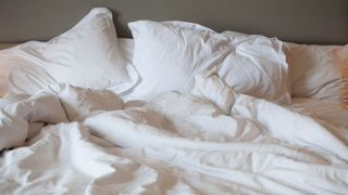 picture of white bedding on unmade bed