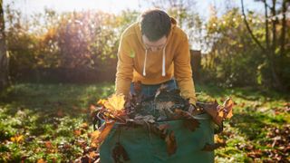 man collected leaves in garden