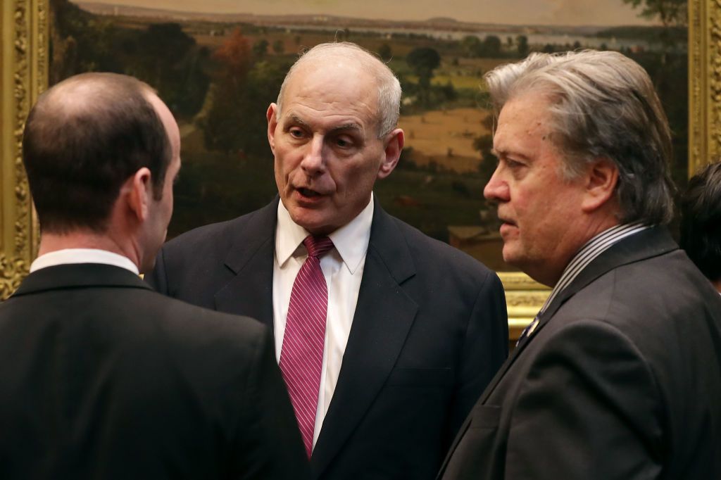 Homeland Security Secretary John Kelly (C) talks with White House Chief Strategist Steve Bannon (R) 