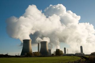 A power plant with billowing pollution spewing from its stacks.