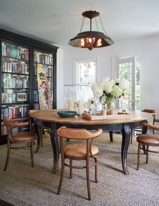 dining room with round wooden table and fitted bookcases