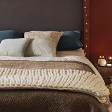 cosy bed with cushions and thick weaved blanket