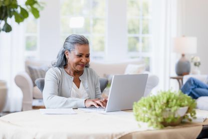 Woman sitting at a table in front of a laptop