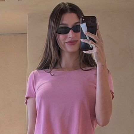 hailey wears sunglasses and a pink cropped tee.