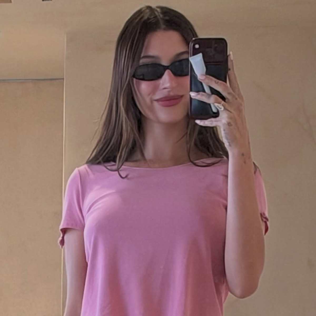 hailey wears sunglasses and a pink cropped tee.
