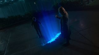 Bode Locke and Gideon stand across from one another in front of a fissure in the ground emitting blue light in Lockey & Key season 3