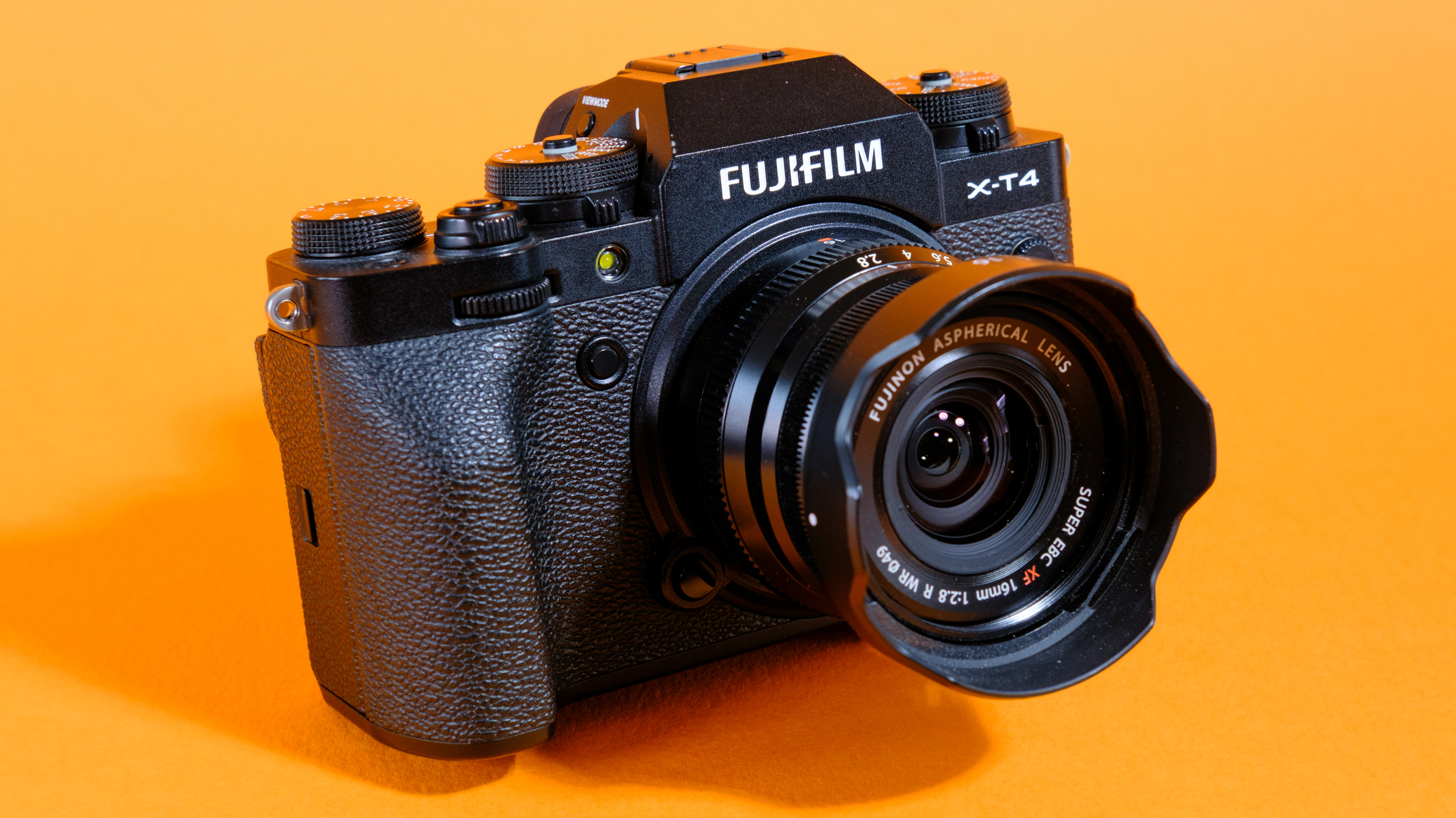 A photo of the Fujifilm X-T4 against an orange background.