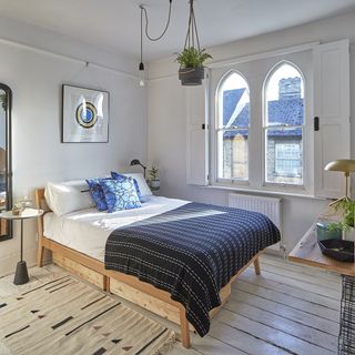 guest bedroom with wooden flooring and white walls