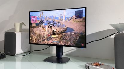 Alienware 27 AW2725Q monitor on desk displaying a scene from Cyberpunk 2077