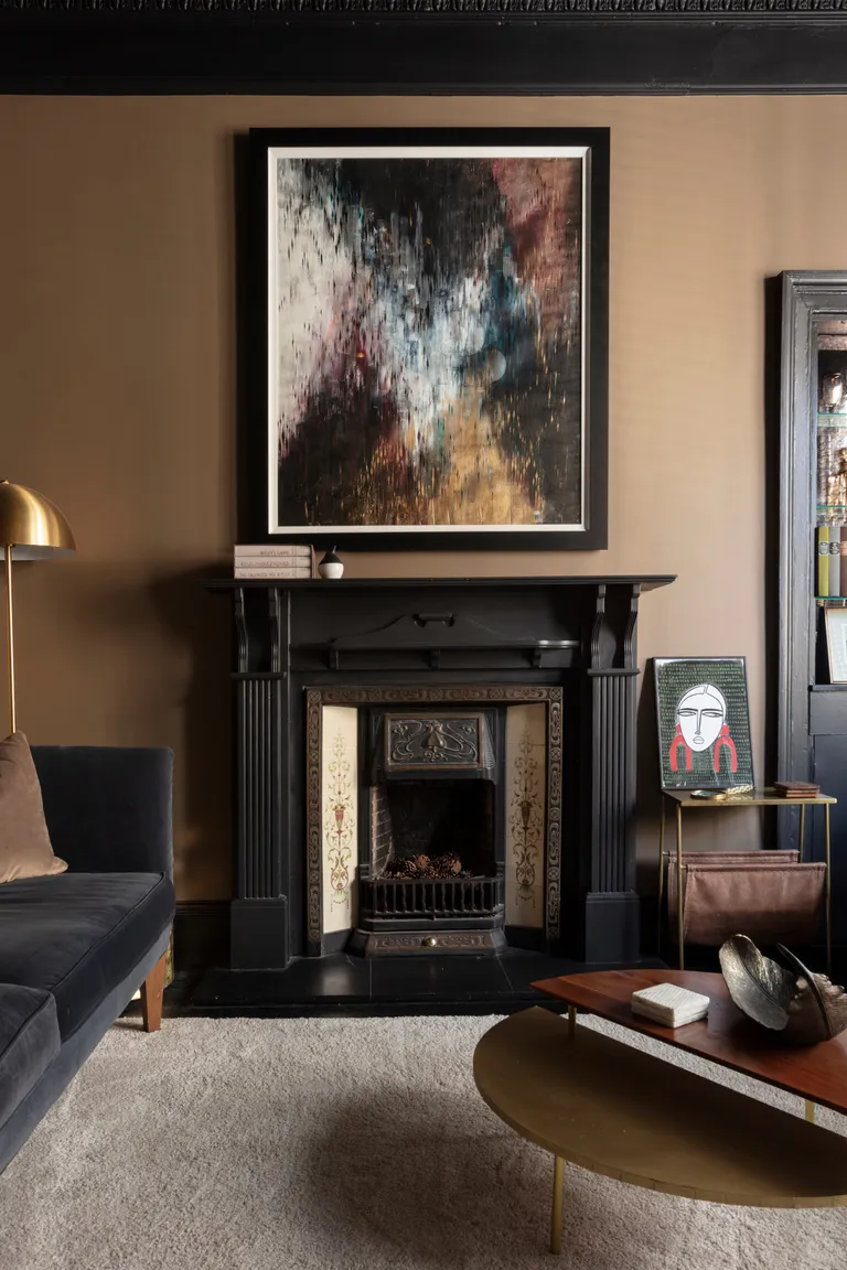 Living room with caramel walls, black painted woodwork and gold accents