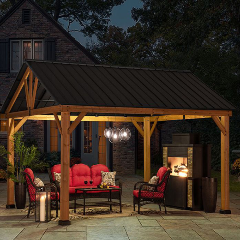 nighttime shot of cedar gazebo with grey aluminium roof lit up and seating below