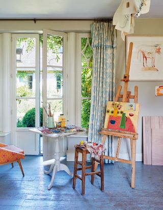 Artist's easel near French window in farmhouse kitchen