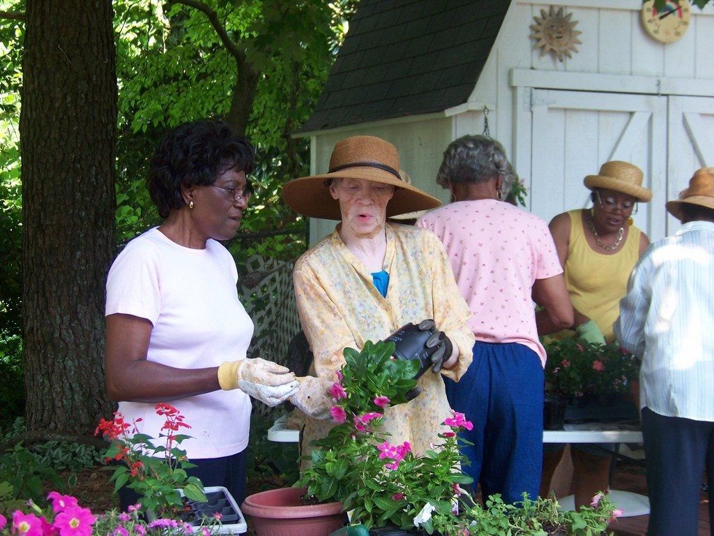 Club Of Gardeners Planting Flowers