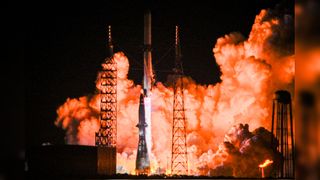 a white rocket launches into a dark night sky