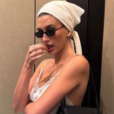 Hailey Bieber styled a lace lingerie-inspired skirt set from Magda Butrym with the triangle hair scarf trend and a new Chanel bag