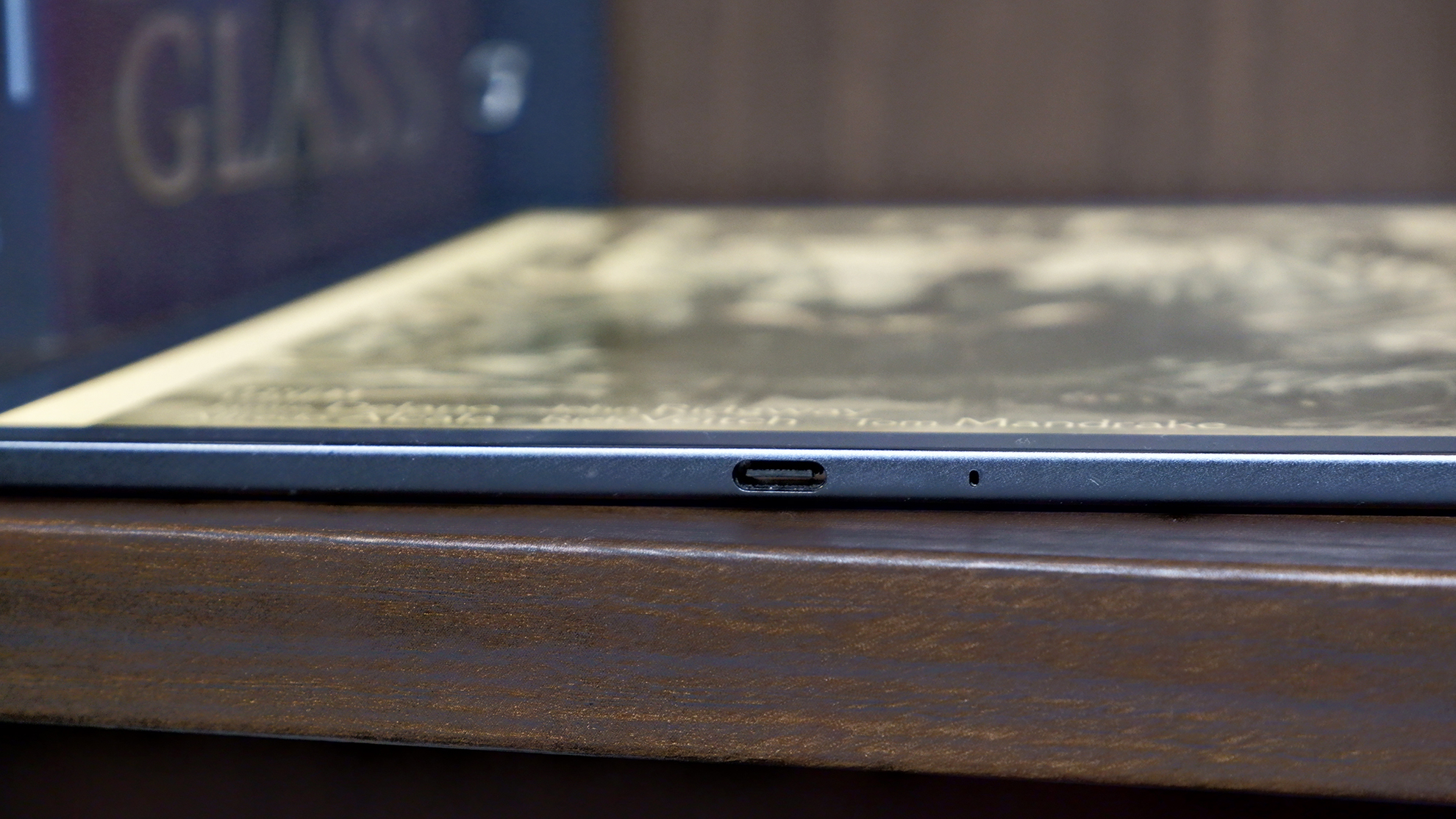 Amazon Kindle Scribe Colorsoft on a bookshelf, showcasing its USB Type-C port.