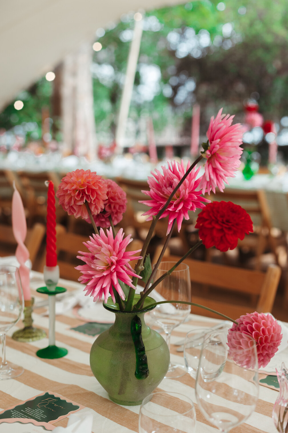 pink flowers on a table setting in green vase