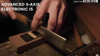 A man sawing something on a woodworking bench