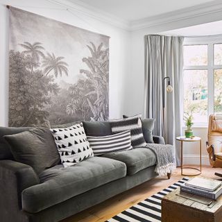 White living room with grey sofa, monochrome wall hanging and wooden floors