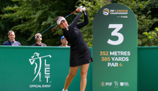 Georgia Hall hits a tee shot in front of a PIF board