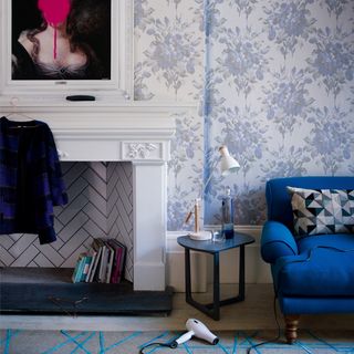 living room with wallpaper and blue armchair