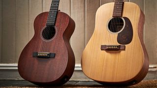 Two Martin acoustic guitars leaning against a wooden wall