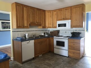 Kitchen before renovation with yellow walls and wood cabinets