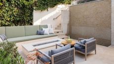 small backyard with sofas and gas fire pit table on patio