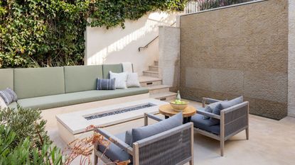 small backyard with sofas and gas fire pit table on patio