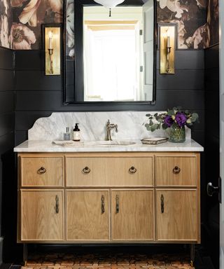 black bathroom ideas, black bathroom with floral wallpaper above black tongue and groove, wood and marble vanity unit, mirror, terracotta style tiles