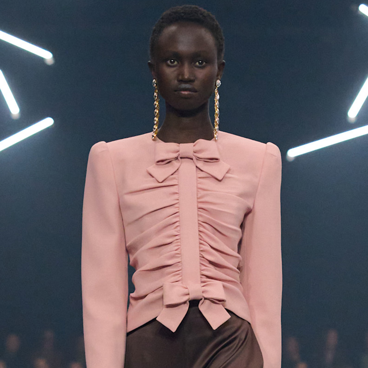 A woman wears a pink top with bows at valentino spring 2026.
