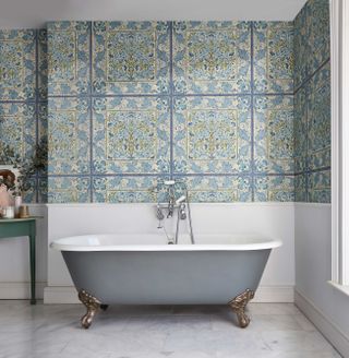 roll-top freestanding bath in a relaxing bathroom with William Morris wallpaper