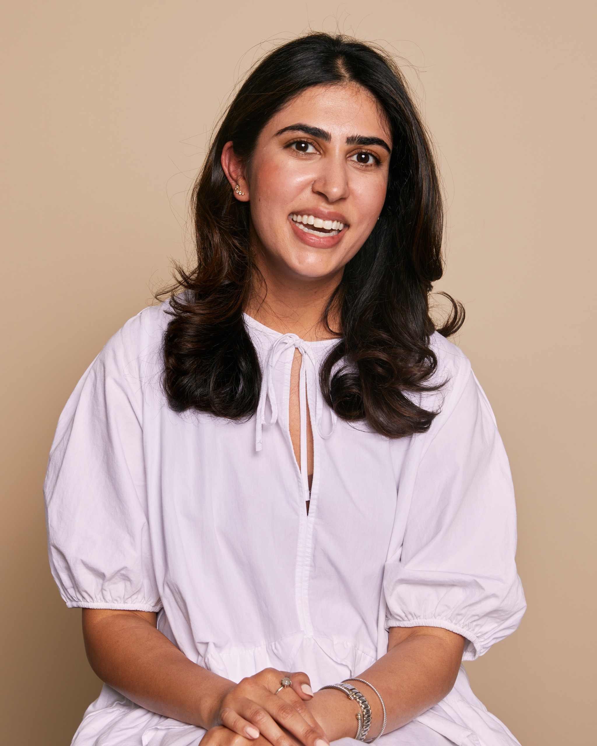 a woman with brown skin and dark hair in a pink dress
