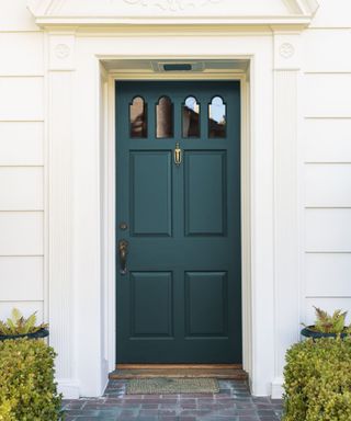 home exterior painted white with dark teal front door