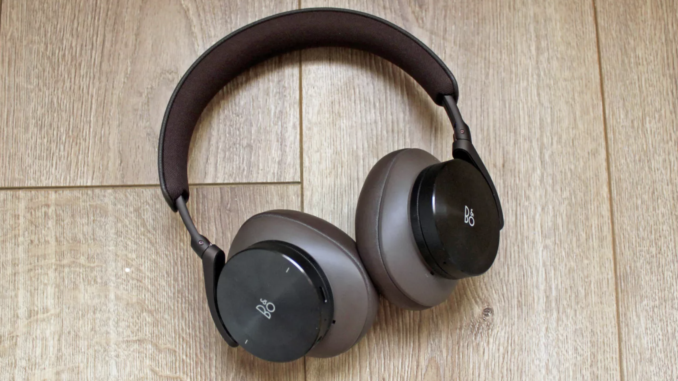 The Bang & Olufsen Beoplay H95 wireless headphones on a wooden surface