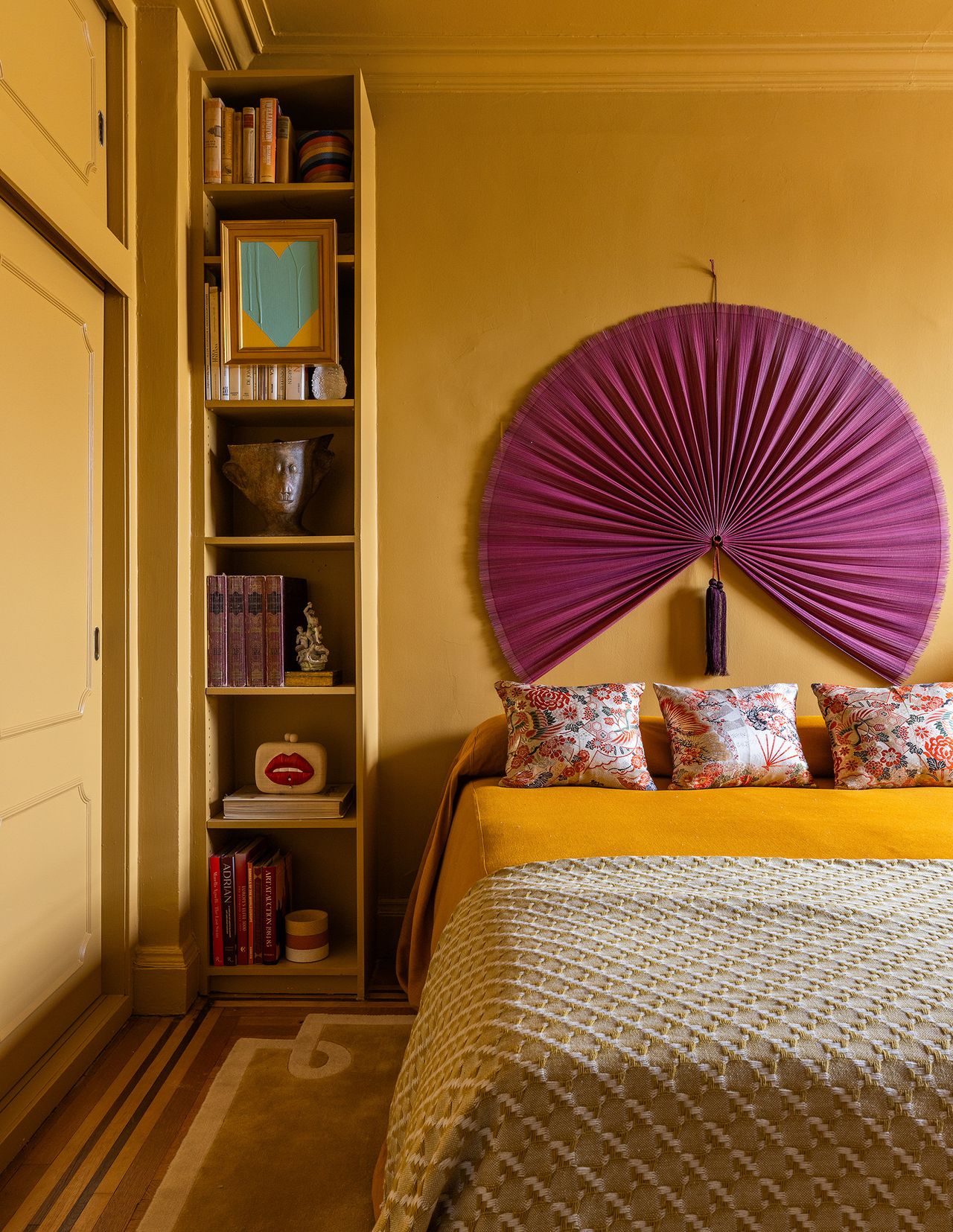 yellow bedroom with purple fan behind bed, yellow color drenched built-in desk under window