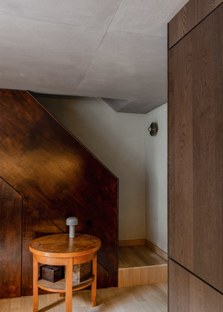 A bronze wood cladded staircase with a statement side table.