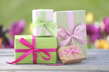 Four wrapped presents displayed on a table. 