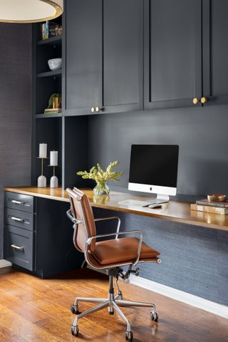 built in desk and cabinetry in dark blue in home office