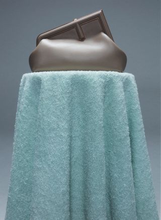 Fendi bag sits on table covered with coloured bath towel