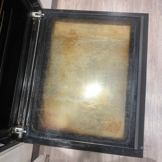 a before picture of oven door. It is very dirty with orange grime.